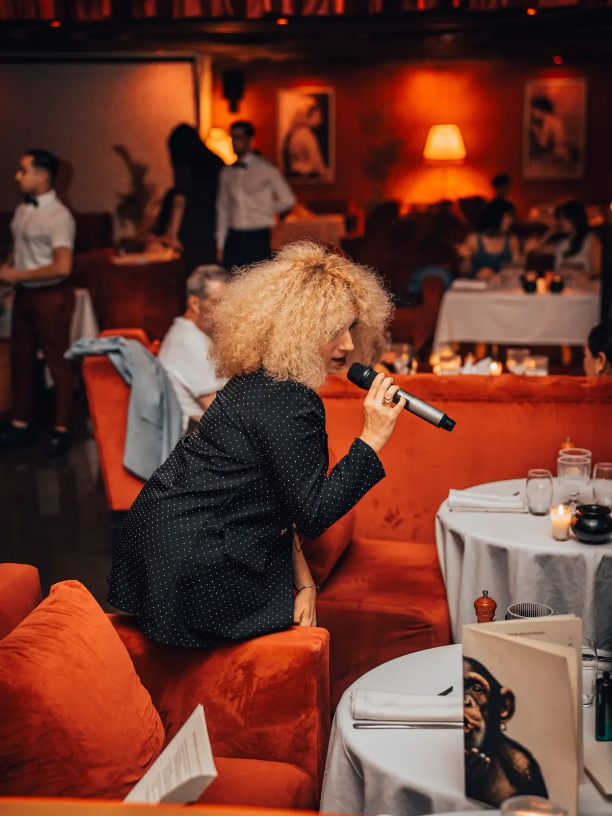 Singer Maureen Angot performing among guests inside LOV Restaurant